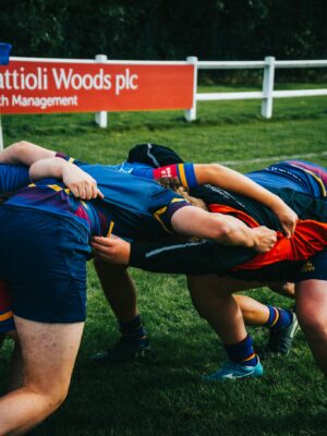 Dynamic rugby players engage in a scrum on a sunny day, showcasing teamwork and sportsmanship.